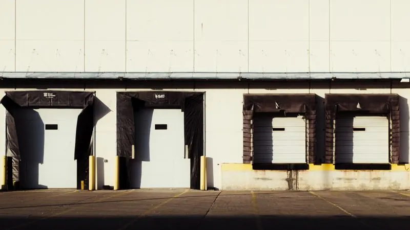 Industrial loading dock with sectional overhead bay doors