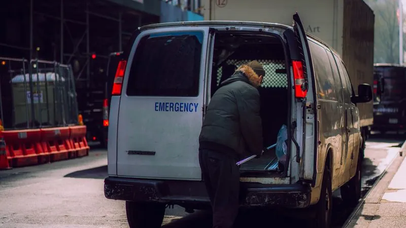 Emergency service van loading equipment on a city street