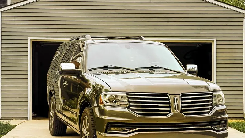 SUV parked in front of a house with a garage door